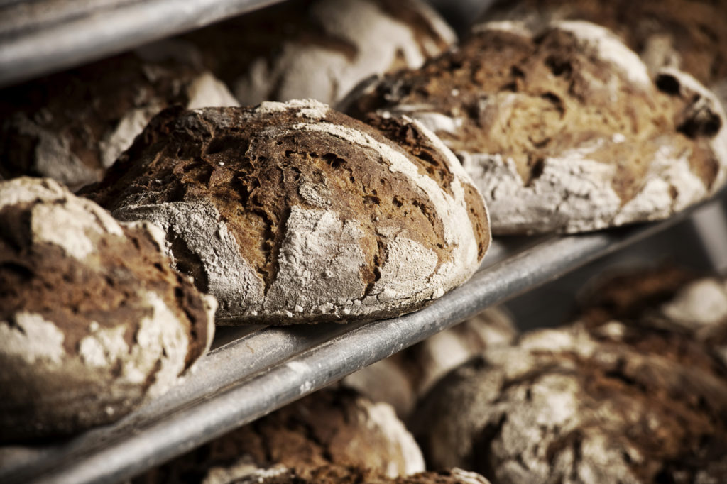 Lovely brown buns on a drying rack Dark brown bread buns fresh out of the oven