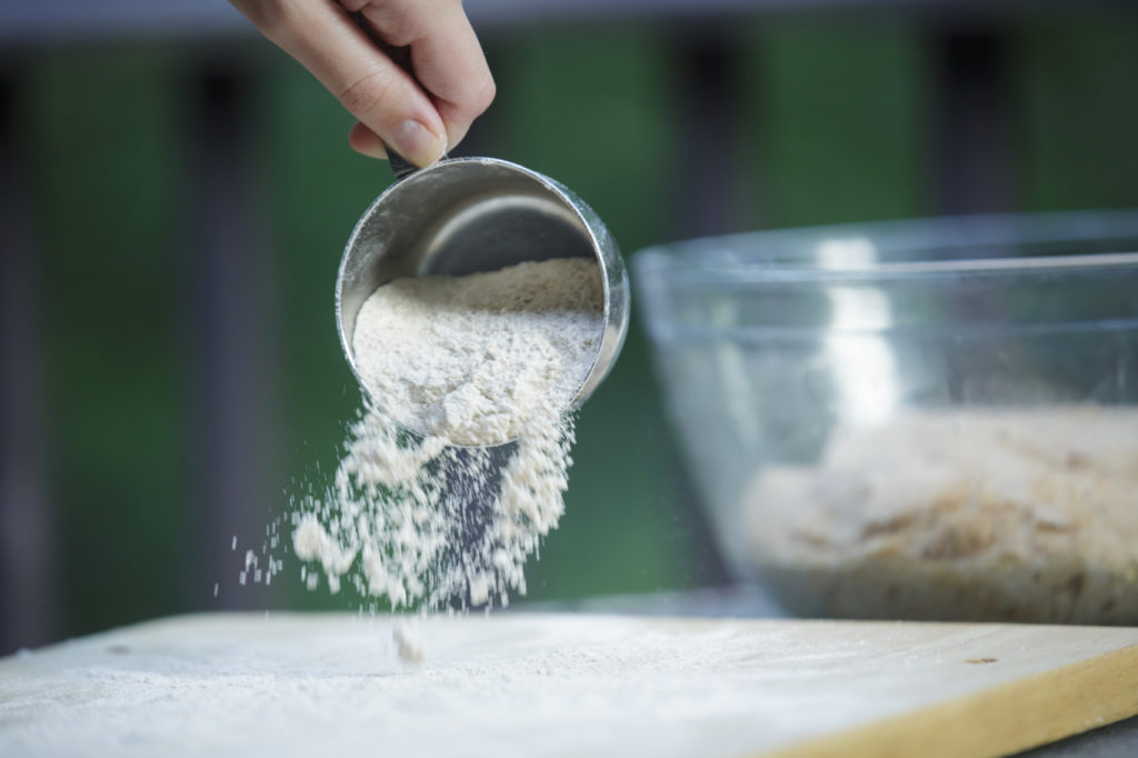 a cup of flour being sprinkled