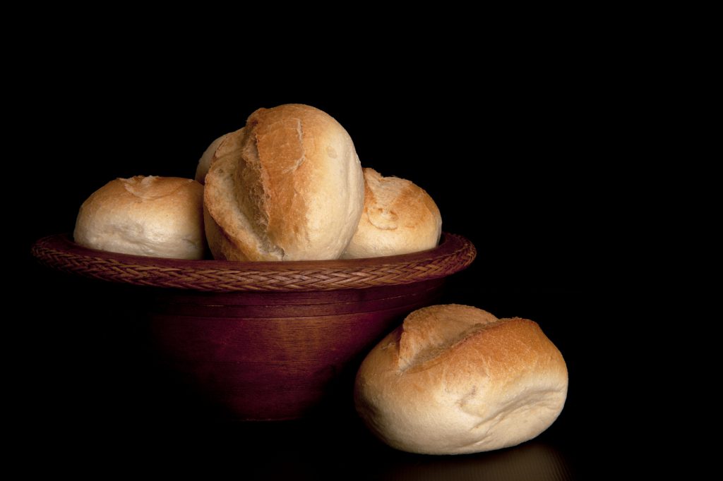 Freshly baked buns in a wooden bowl.