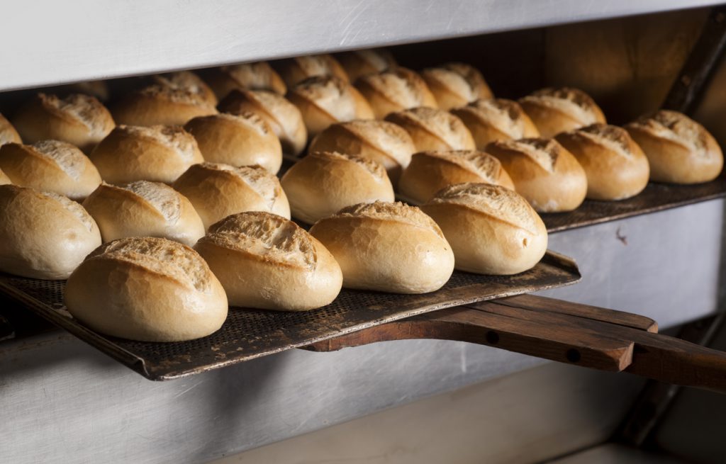 Putting buns in oven Baking fresh bread in bakery
