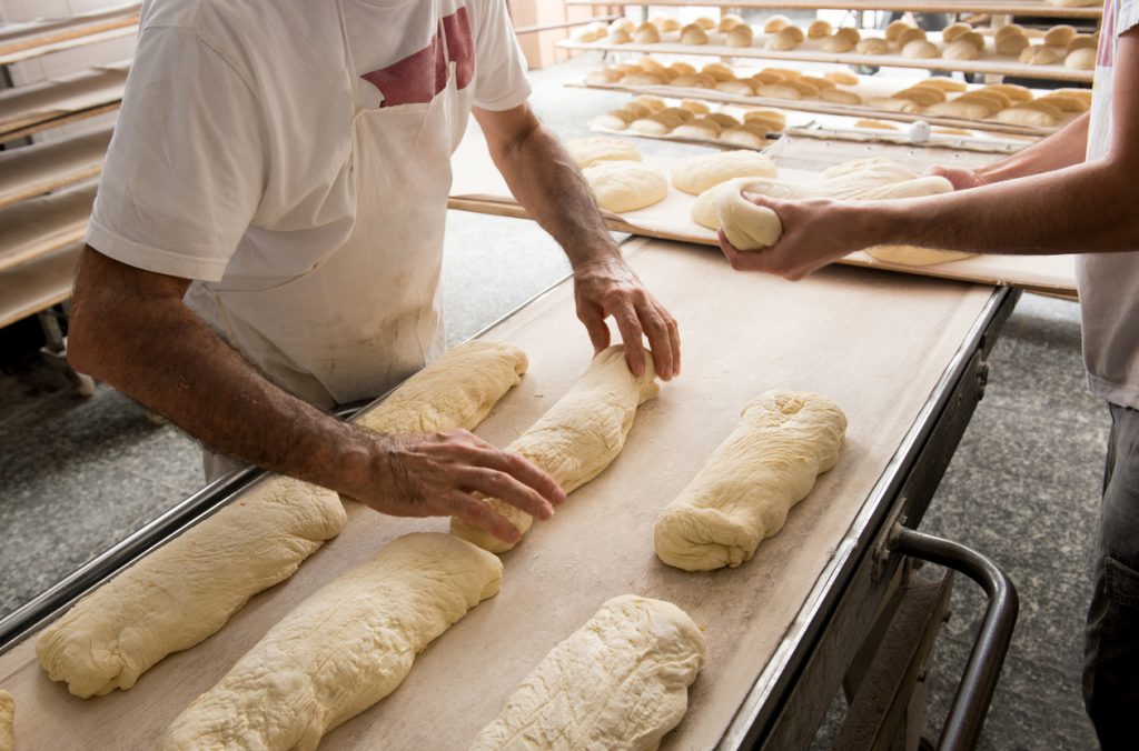 Bakers putting bread to a band for oven Baking long loaves
