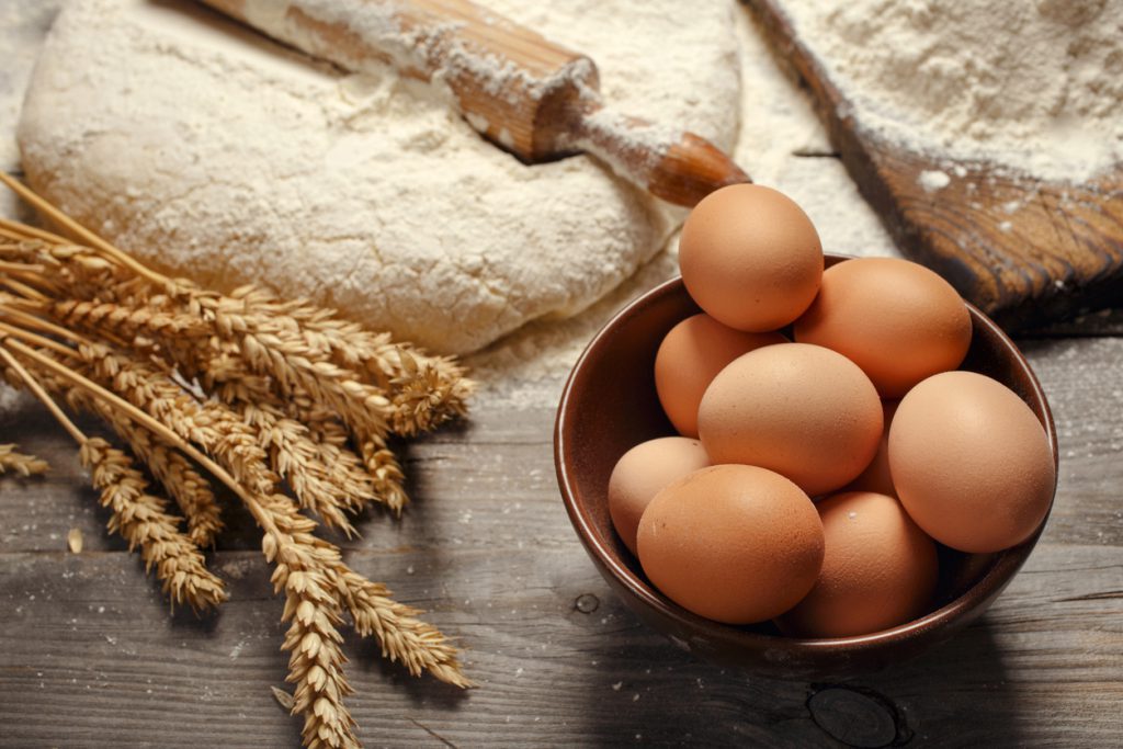 Brown eggs in a bowl close up in a bakery Fresh bread ingredients on a table