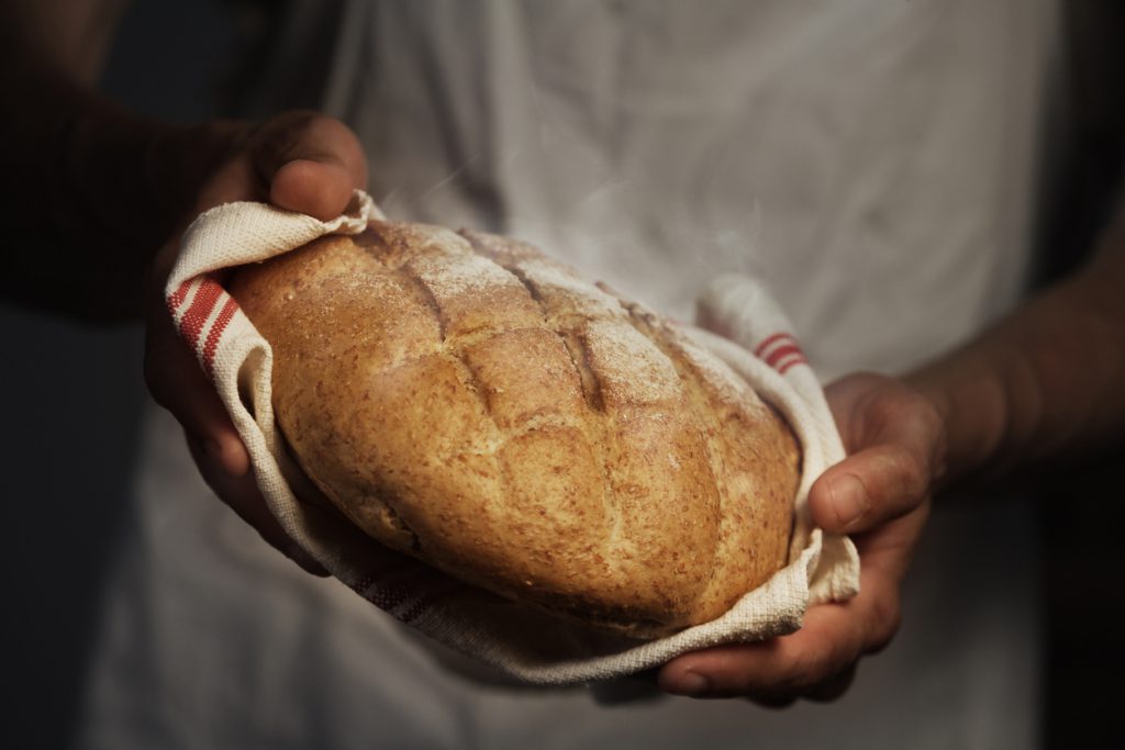Baker man holding a warm bread
