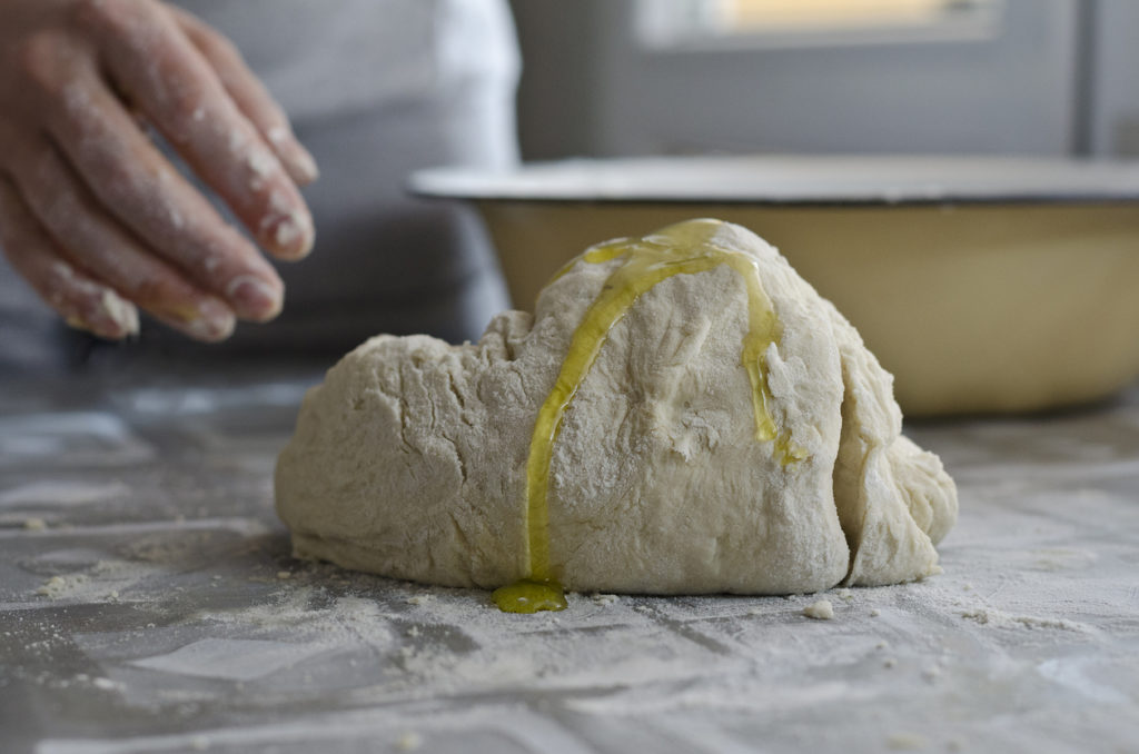 Female hands in flour closeup kneading dough