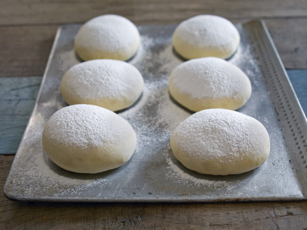 tray of bread dough balls on table top